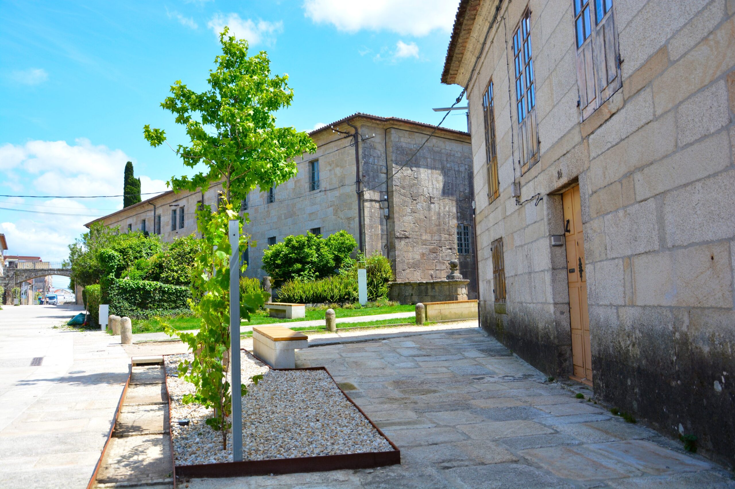 Calle Antero Rubun: imagen de una jardinera con vegetación en una calle y al fondo el edificio del antiguo convento de Santo Domingo